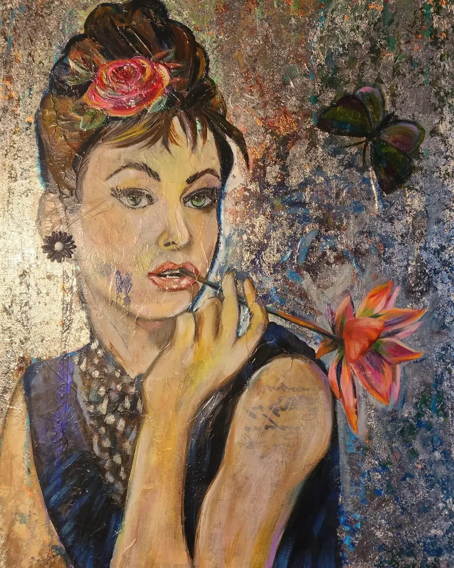 A woman holding a lily, with a rose in her hair