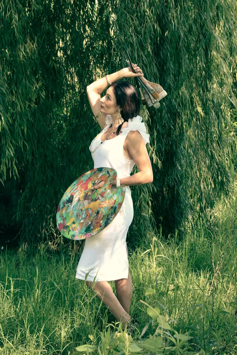 Jullie-Ann Viljoen with her palette and brushes beneath a willow