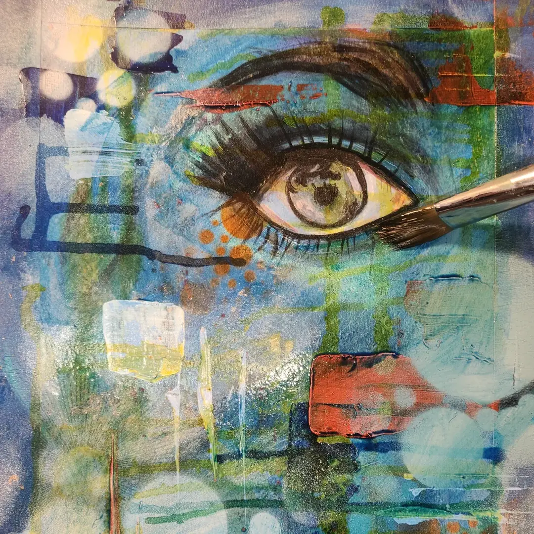 A paintbrush shaping the brow and lashes of a painted eye, mixed media by Jullie-Ann Viljoen